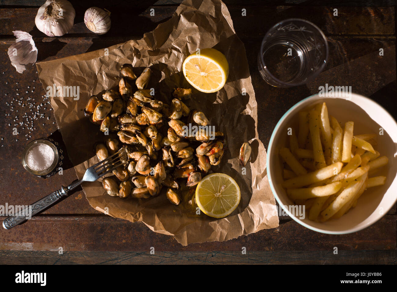 Muscheln mit Zitronen und Pommes frites in der Draufsicht Metall Hintergrund Stockfoto