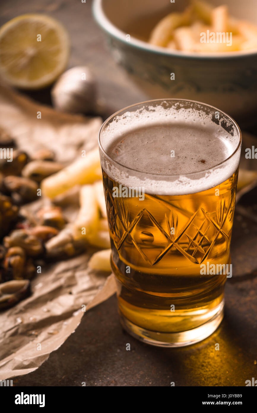 Glas Bier mit unscharfen Snack auf dem Metall Hintergrund Stockfoto