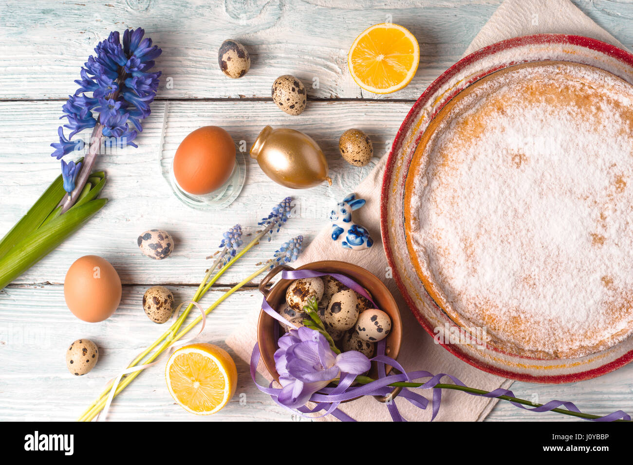 Deutsch Osterkuchen mit Dekoration und Blumen auf dem horizontalen weißen Holztisch Stockfoto