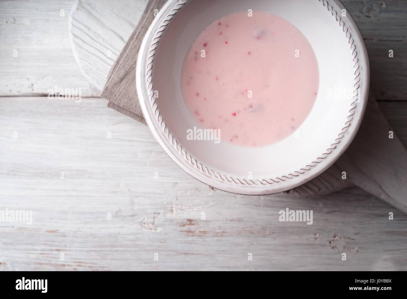 Beere Joghurt in die weiße Platte auf dem horizontalen weißen Holztisch Stockfoto