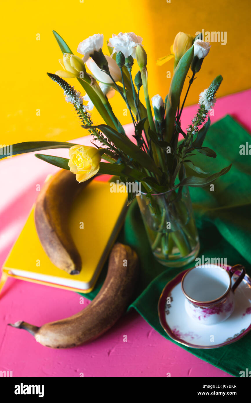 Strauß Tulpen und Nelken auf einem rosa Tisch Stockfoto