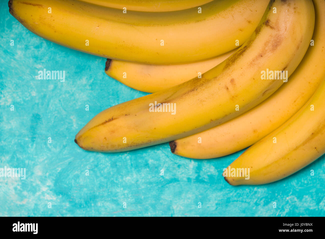 Ganze Bananen auf einer freien Fläche Türkis Hintergrund Stockfoto