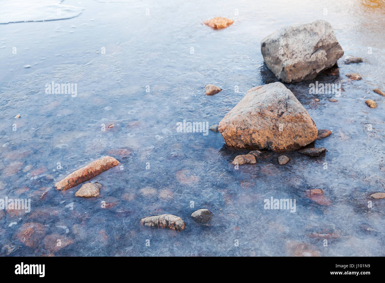 Steinen lag am Saimaa-See Küste mit Eis bedeckt Stockfoto