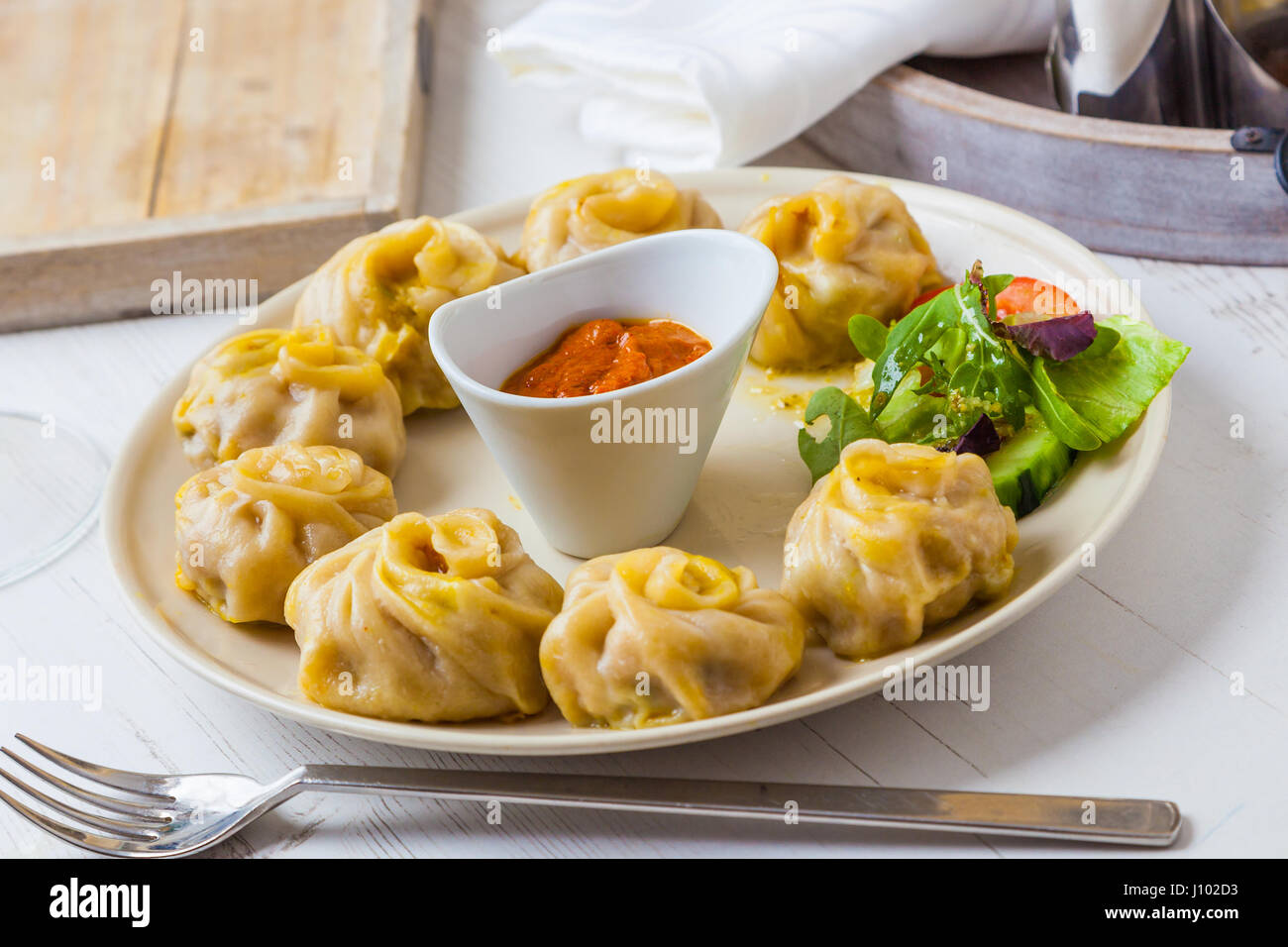 Nepalesische traditionellen Knödel Momos mit Tomate Chatni und frischem Salat serviert. Stockfoto