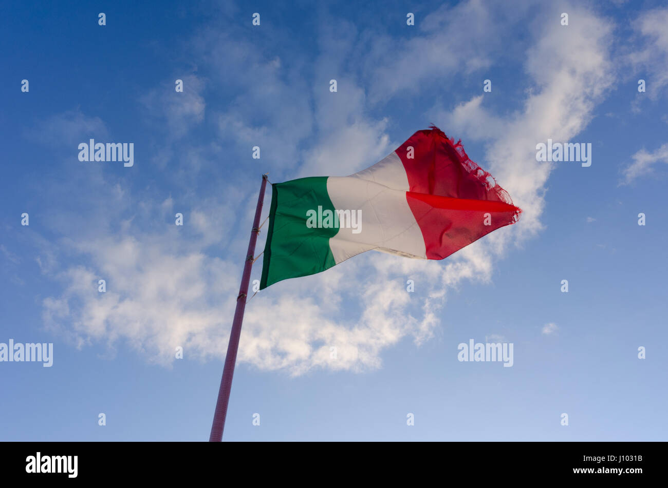 Eine ausgefranst italienische Flagge, die in der Sonne fliegt Stockfoto