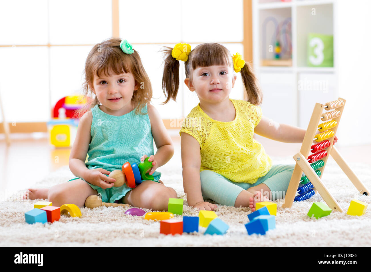 Kinder spielen zusammen. Baby und Kleinkind Kinder spielen mit Blöcken. Pädagogische Spielwaren für Vorschule und Kindergarten Kind. Kleine Mädchen bauen Block Spielzeug Stockfoto