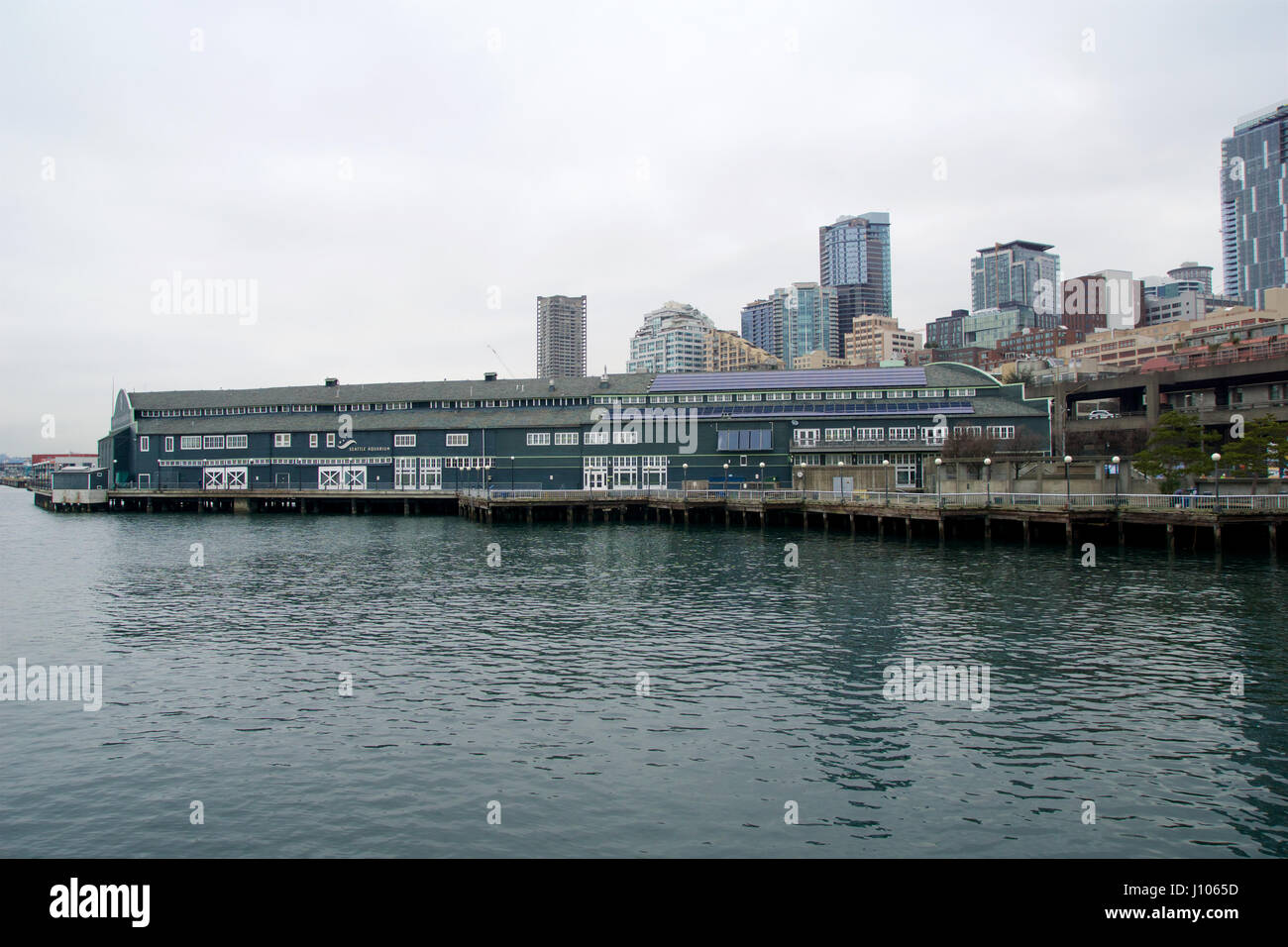 SEATTLE, WASHINGTON, USA - 25. Januar 2017: Ein Blick auf Seattle downtown aus den Gewässern des Puget Sound. Piers, Wolkenkratzer, Seattle Aquarium in der Stadt vor Sonnenuntergang Stockfoto