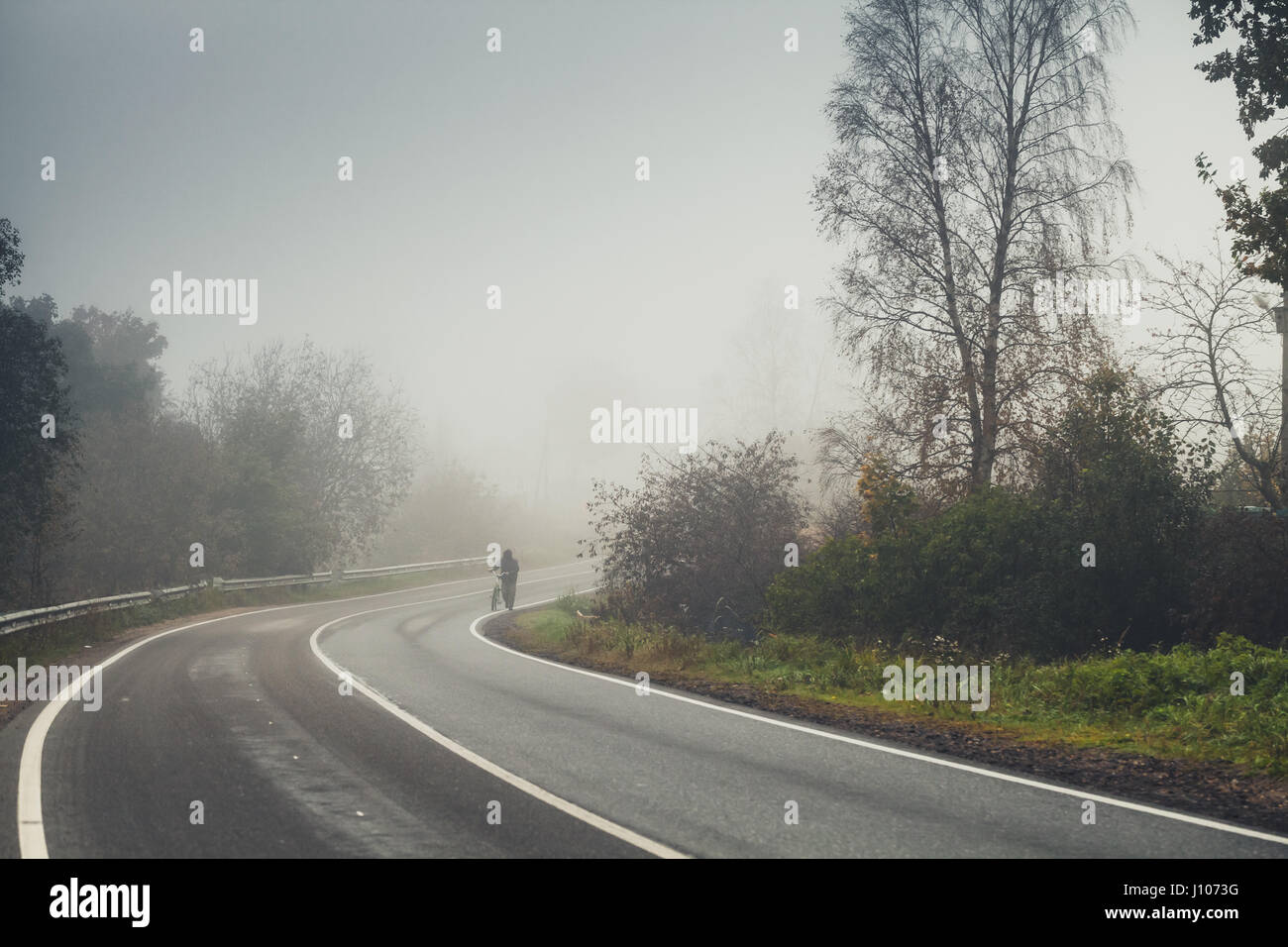 Leerer Landstraße Wende in nebligen Herbstmorgen, Vintage Tonwertkorrektur Wirkung, alten Stil Fotofilter Stockfoto