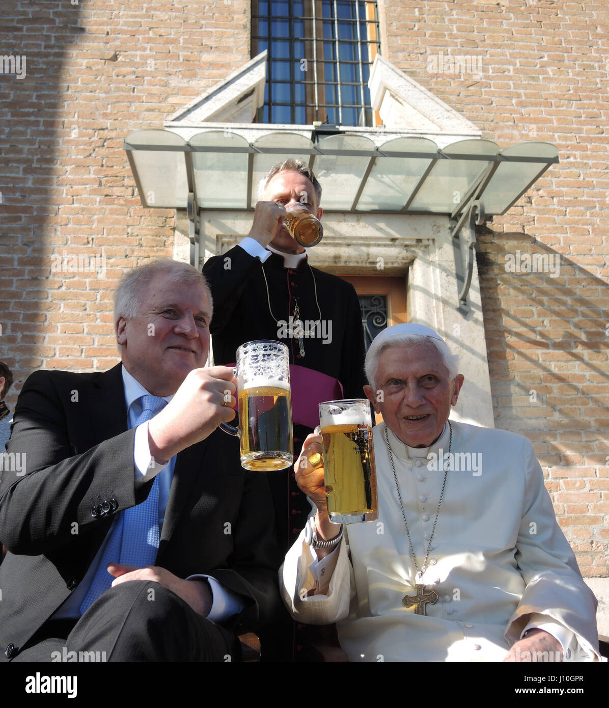 Vatikan. 17. April 2017. Der pensionierte Pope Benedict XVI (R) und Premier des Freistaates Bayern, Horst Seehofer (CSU), trinken Sie ein Glas Bier im Vatikanischen Garten in der Vatikanstadt, 17. April 2017. Benedikts Privatsekretär Georg Gaenswein steht hinter den beiden. Benedikt feiert seinen 90. Geburtstag und erhielt Besucher aus Bayern, dem Bundesland, aus dem er stammt. Seine eigentlichen Geburtstag feierte mit einem kleinen Kreis von vertrauten wie sein älterer Bruder Georg, Gaenswein und seine Haushälterin. : Bildnachweis Lena Klimkeit/Dpa: Dpa picture-Alliance/Alamy Live News Stockfoto