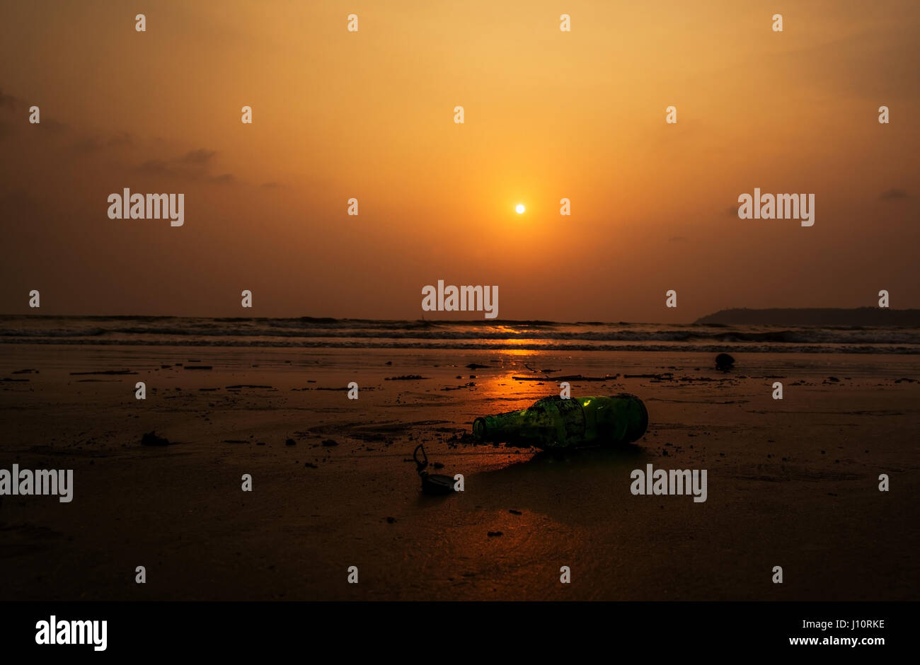 Bierflasche geworfen am Strand mit Schlamm bedeckt Stockfoto