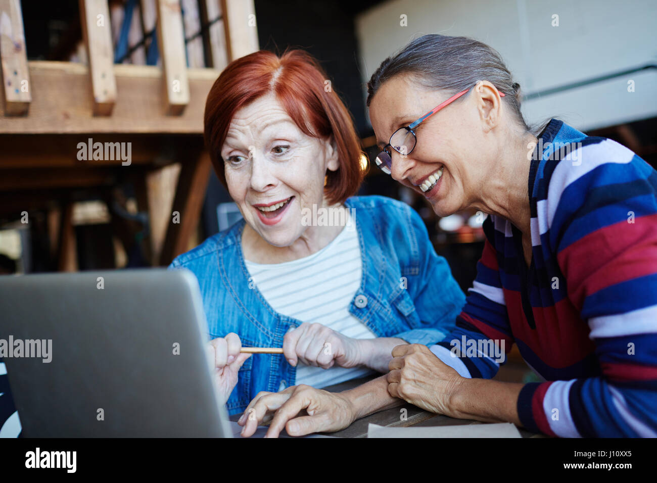 Zwei neugierige Reifen Weibchen Blick auf Laptop-display Stockfoto