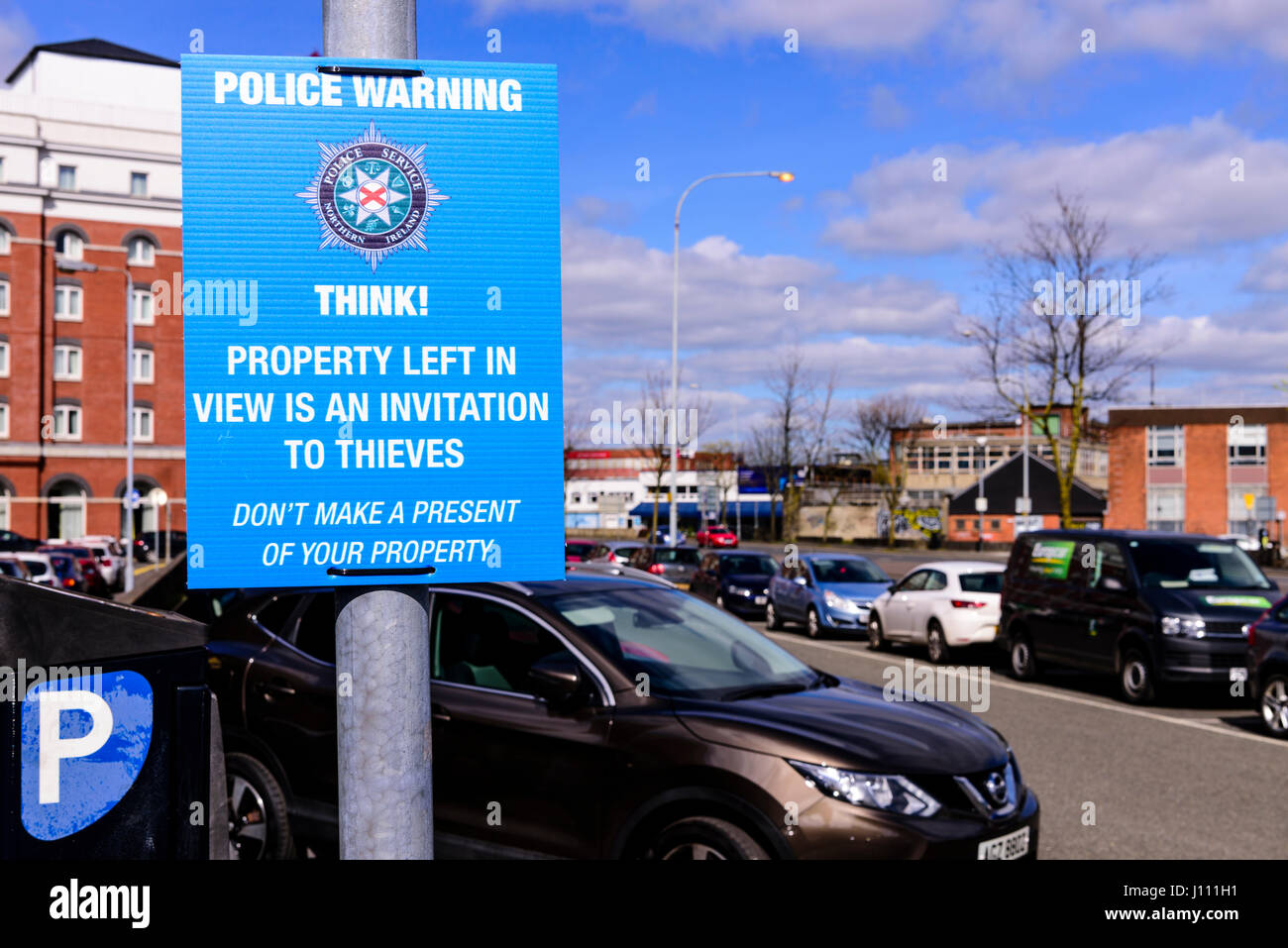 Schild am ein Parkplatz zur Verfügung gestellt von der Polizei "Police Warnung. Denke! Eigenschaft im Blick nach links ist eine Einladung für Diebe. Machen Sie kein Geschenk Ihres Eigentums. Stockfoto