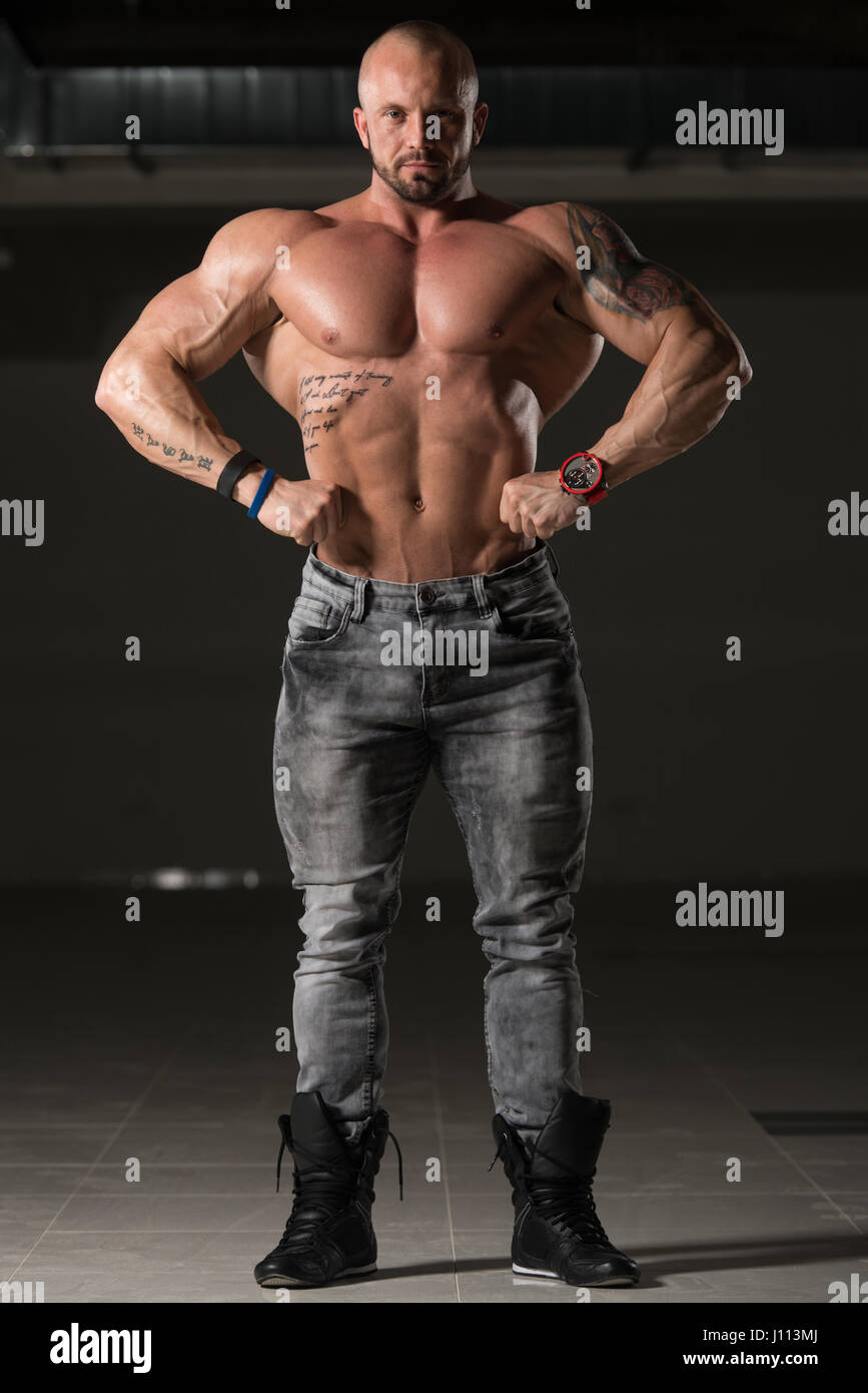 Gesunde Jungtiere Tattoo Mann In Hosen und biegen Muskeln starke muskulöse athletische