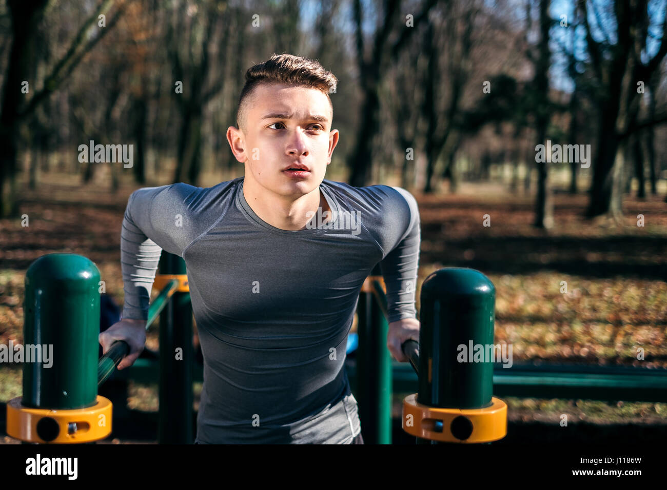 Mann macht Liegestütze auf Bars im Park, Minsk, Belarus Stockfoto