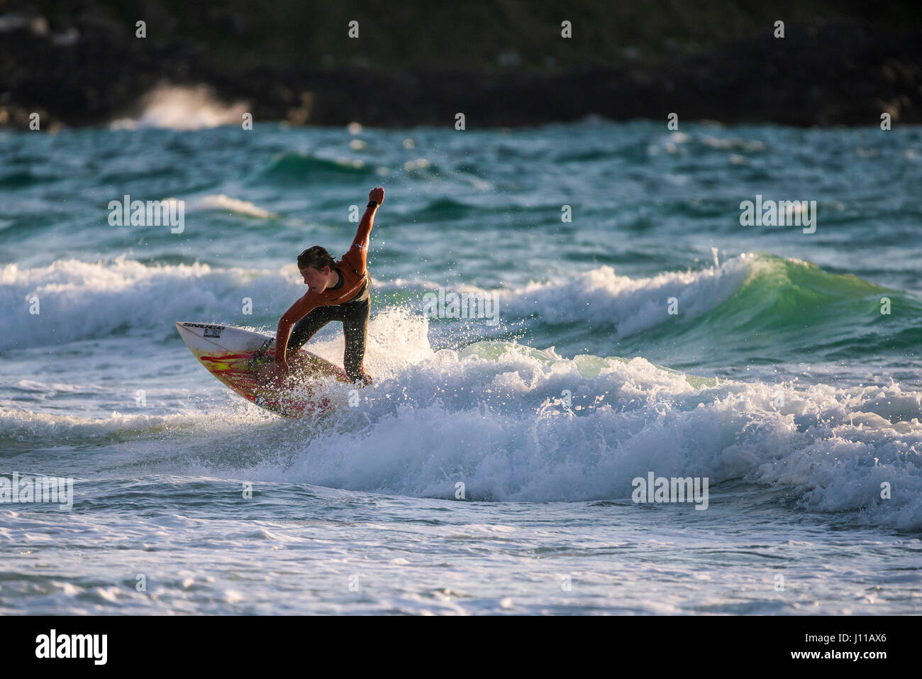 Surfen-UK; Surfer; Fistral; Cornwall; Welle; Surfbrett; Meer; Spray; Watersport; Am Abend; Körperliche Aktivität; Skill; Spektakuläre Action; Freizeit Aktivitäten Stockfoto