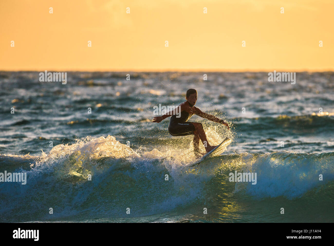 Surfen GROSSBRITANNIEN; Surfer; Sonnenuntergang; Fistral; Cornwall; Spray; Abend licht; Wave; Surf Board; Meer; Wassersport; Abend; körperliche Aktivität; Fähigkeit; Spektakuläre Stockfoto