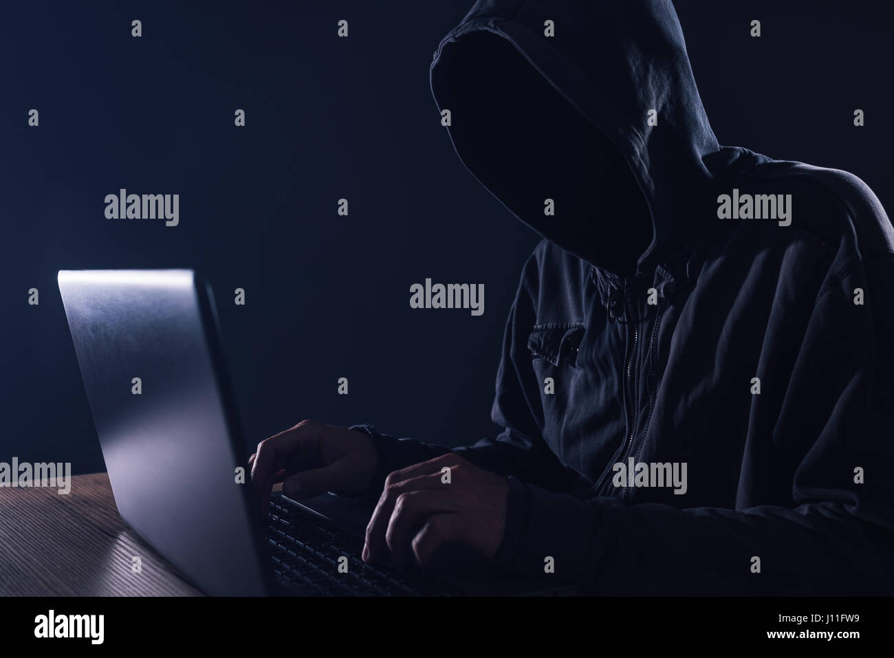 Hacker, Hardware-Firewall auf Laptop-Computer, vermummte männliche Cyber-Kriminellen zu umgehen Stockfoto