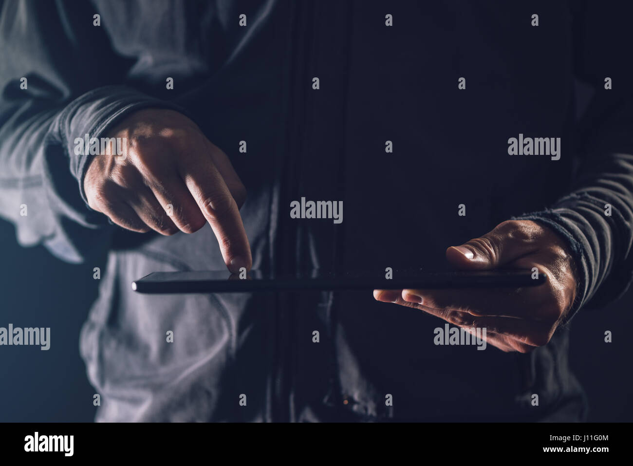 Digitalen Tablet-Computer in männlichen Händen im dunklen Raum, unaufdringlich hautnah Stockfoto