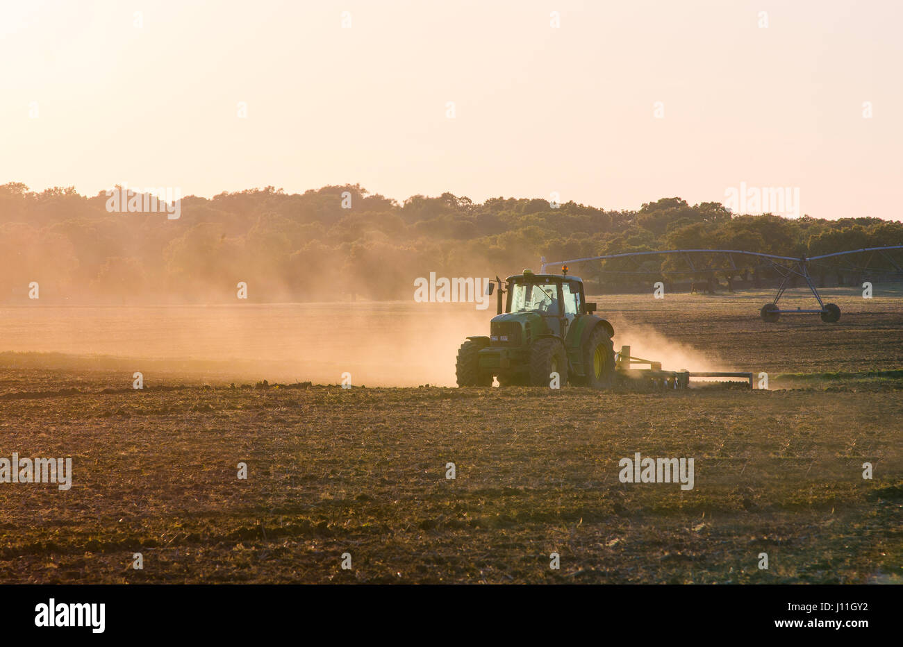 Traktor arbeiten auf einem Bauernhof in der Dämmerung Stockfoto