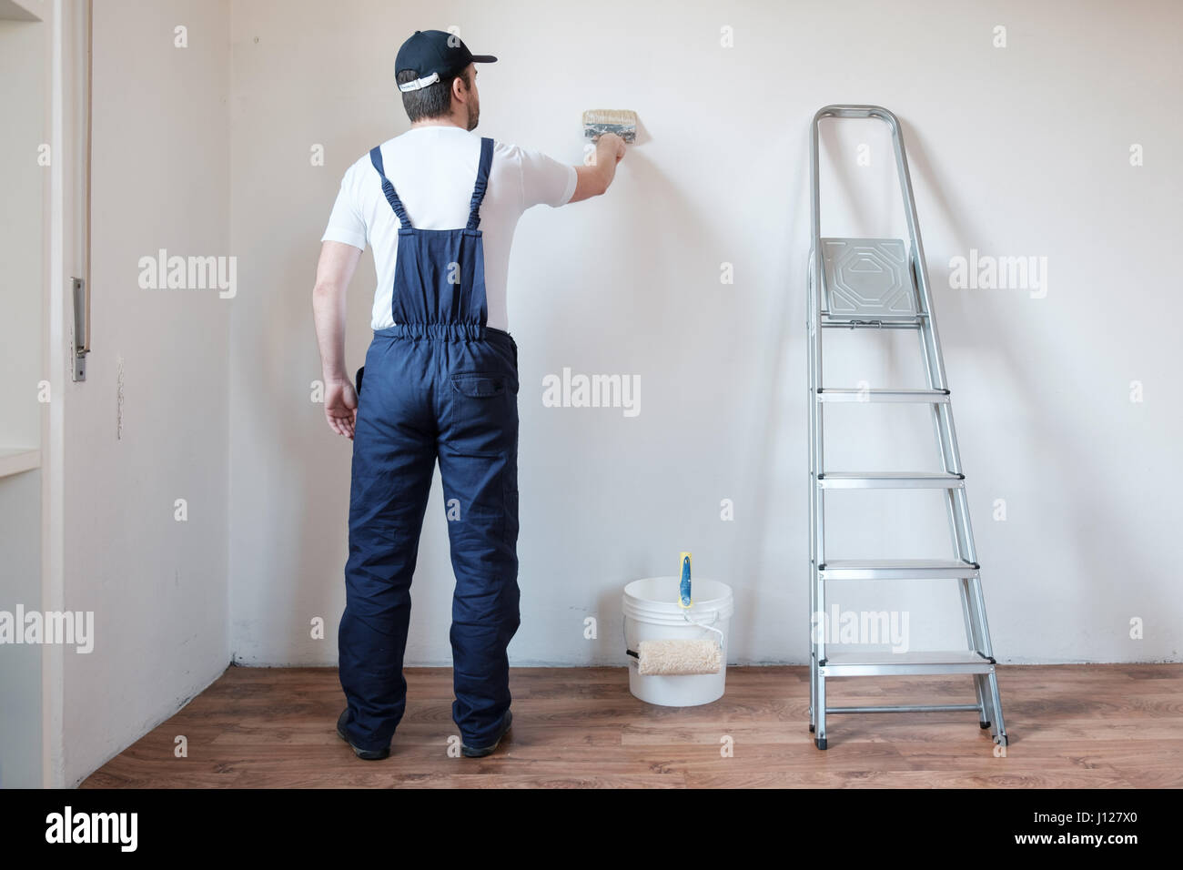 Professionelle Maler Arbeiter ist eine Wand malen. Stockfoto