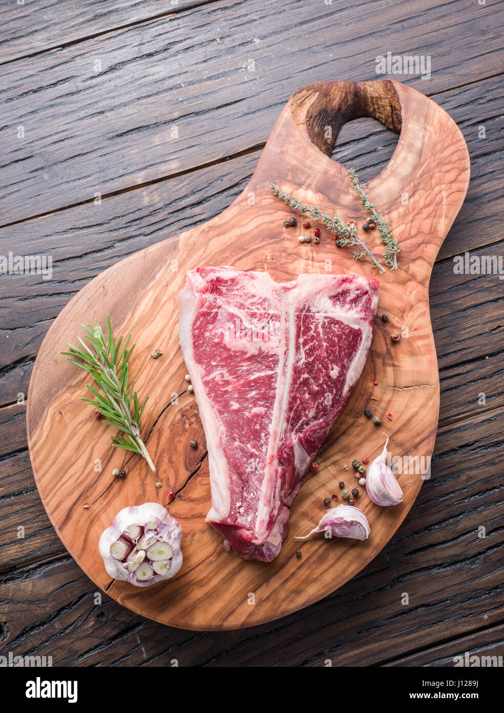 T-Bone Steak-mit Gewürzen auf dem Holzbrett. Stockfoto