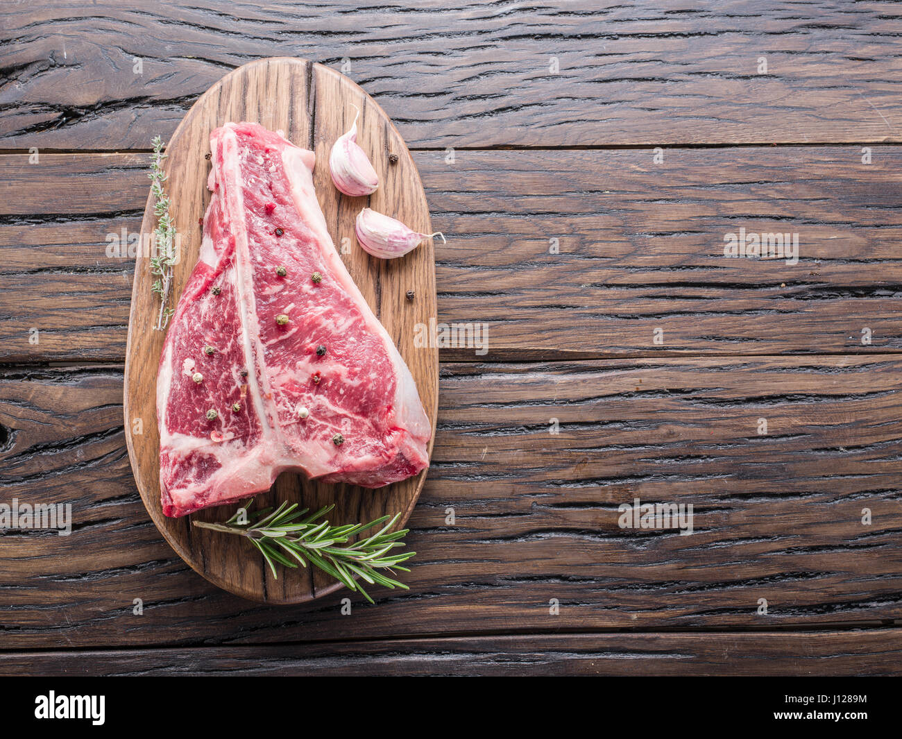 T-Bone Steak-mit Gewürzen auf dem Holzbrett. Stockfoto