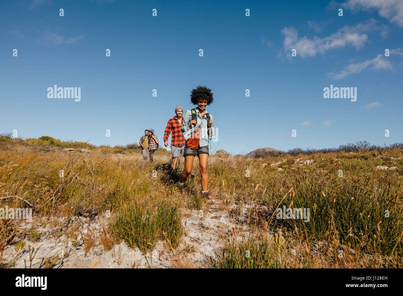 Gruppe von Freunden zu Fuß durch die Landschaft. Junge Menschen wandern in der Natur. Stockfoto