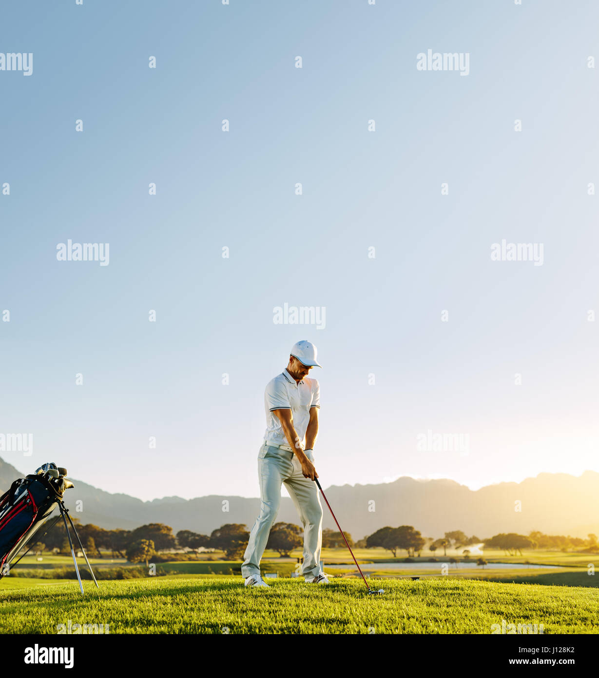 Voller Länge der männlichen Golfer unter Schuss stehend auf Golfplatz. Professioneller Golfspieler auf sonnigen Tag zu spielen. Stockfoto