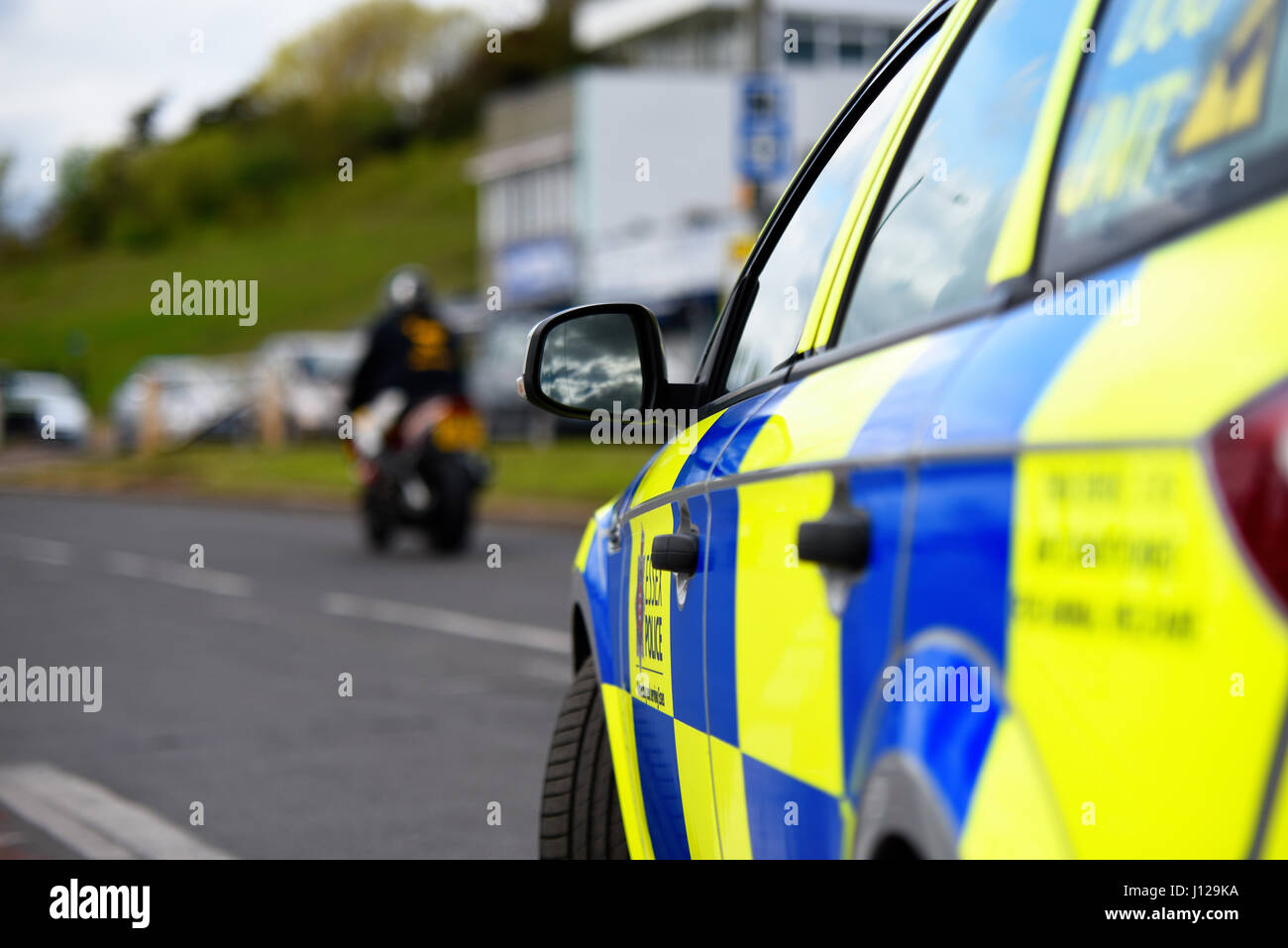 Polizeiauto geparkt, während ein Motorrad geht. Keine Flächen sichtbar. Mit Platz für Kopie Stockfoto