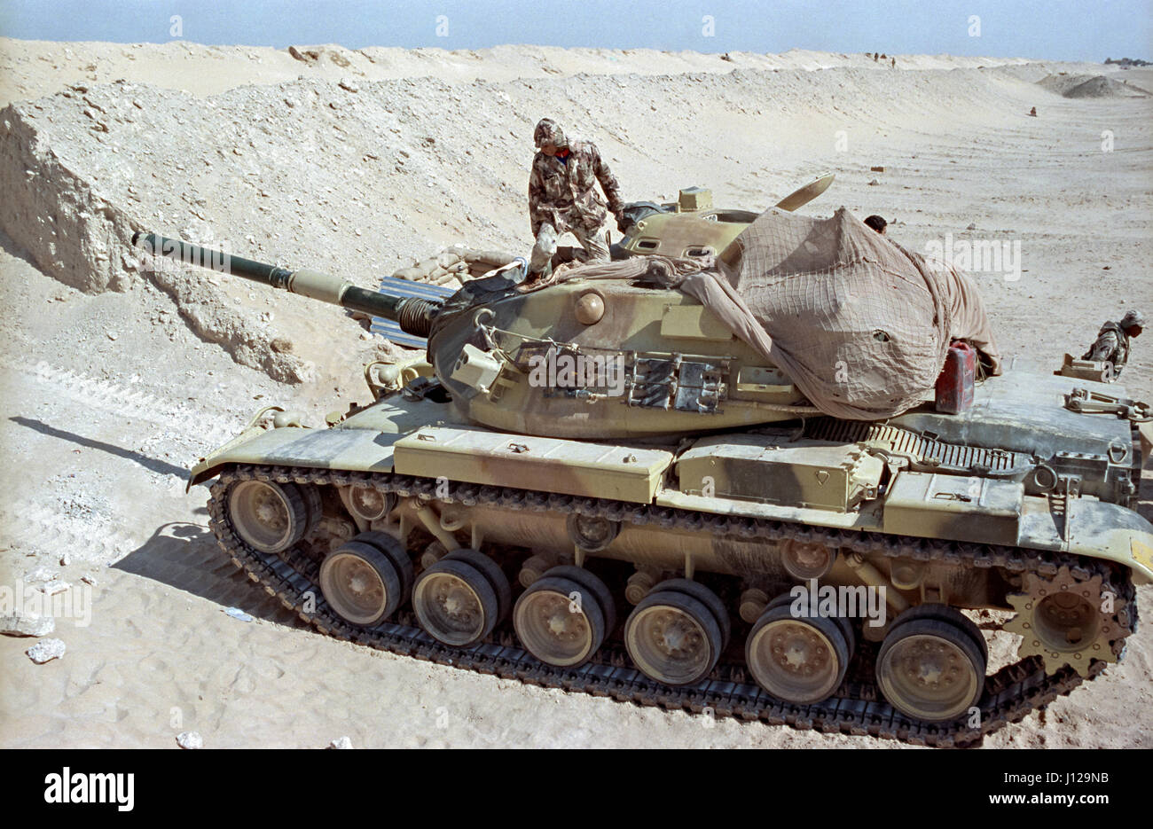 Ein ägyptischer Soldat Positionen ein Kampfpanzers M60 entlang der Sand Berme Grenzmauer an der Front, der Trennung von Kuwait aus Saudi Arabien 8. Februar 1991 in Ar Ruqi, Saudi Arabien. Stockfoto