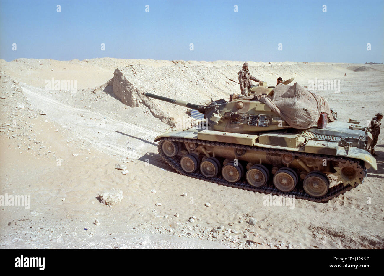 Ägyptische Soldaten Positionen ein Kampfpanzers M60 entlang der Sand Berme Grenzmauer an der Front, der Trennung von Kuwait aus Saudi Arabien 8. Februar 1991 in Ar Ruqi, Saudi Arabien. Stockfoto