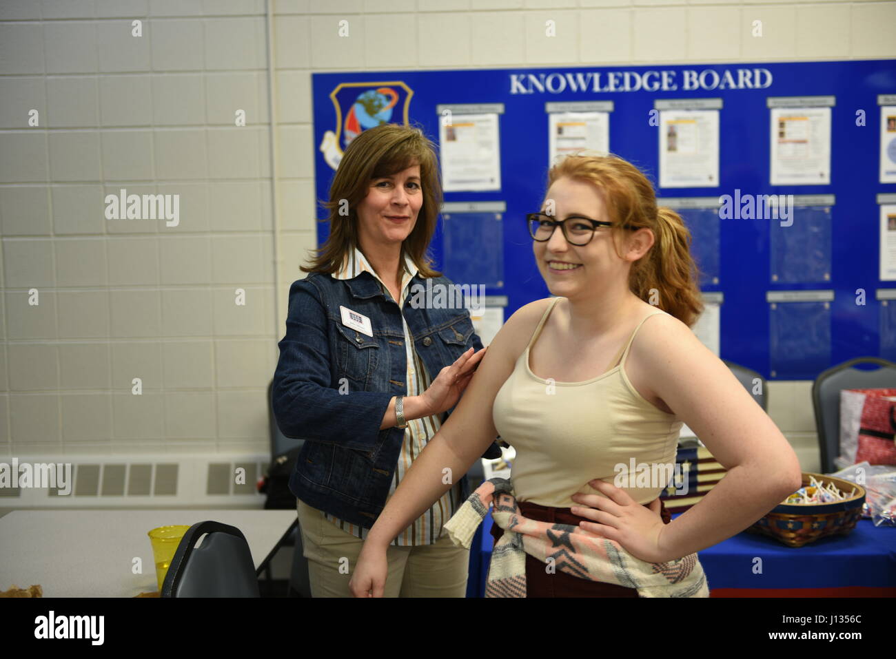 Der USO North Carolina verleiht ein Familienmitglied ein bereitgestellten N.C. Air Gardist, gleichzeitig aber eine starke Anleihen-Event an der North Carolina Air National Guard Base, Charlotte Douglas International Airport, 27. März 2017 temporäre Tattoos. Starke Bindungen ist eine Veranstaltung, die Familien der bereitgestellten Flieger, eine Gemeinschaft von Unterstützung schaffen zusammen zu bringen. Stockfoto
