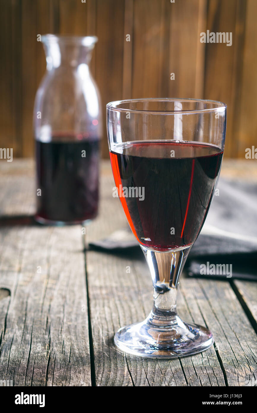 Glas Rotwein auf Holztisch. Stockfoto