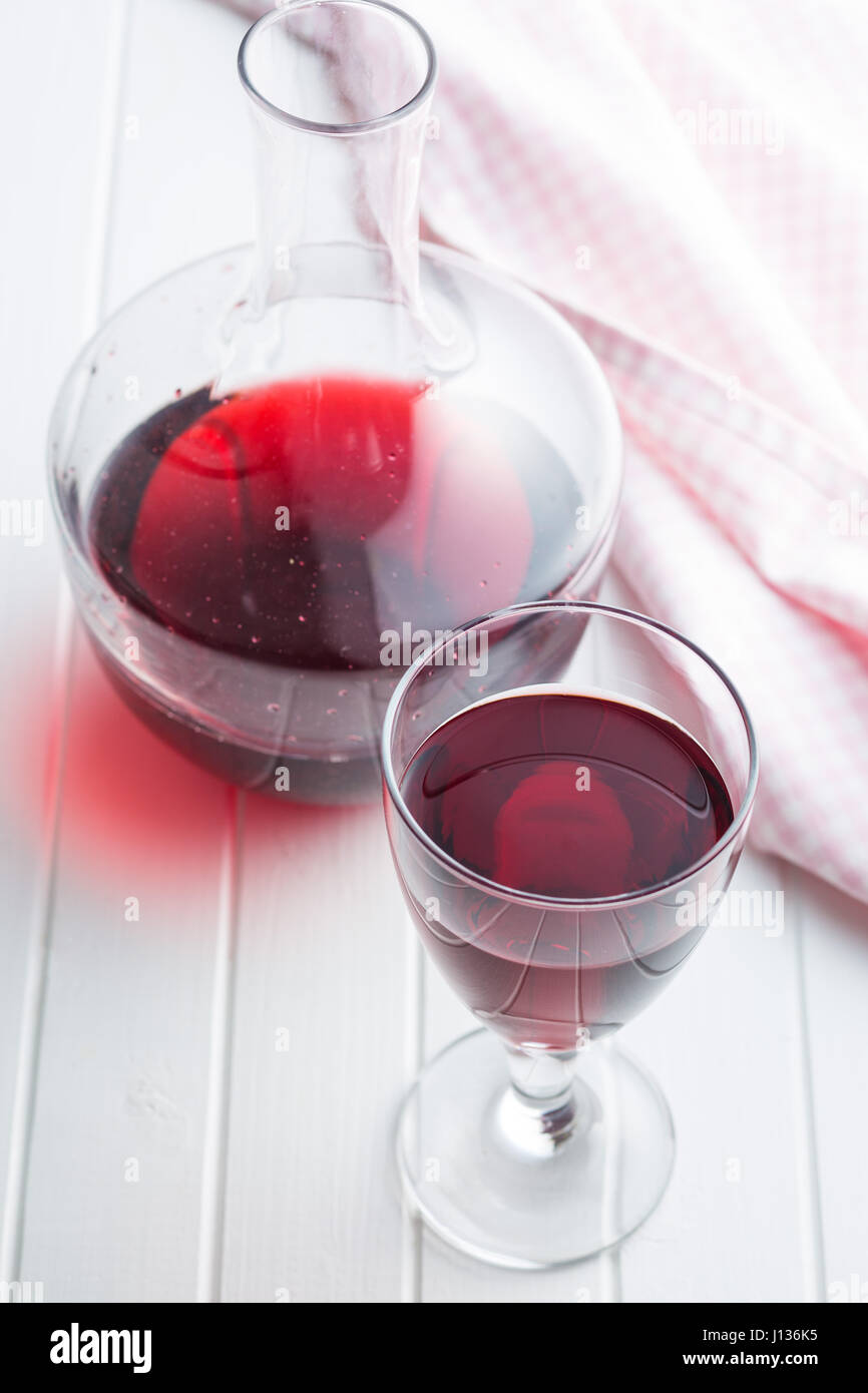 Glas Rotwein auf weißen Tisch. Stockfoto
