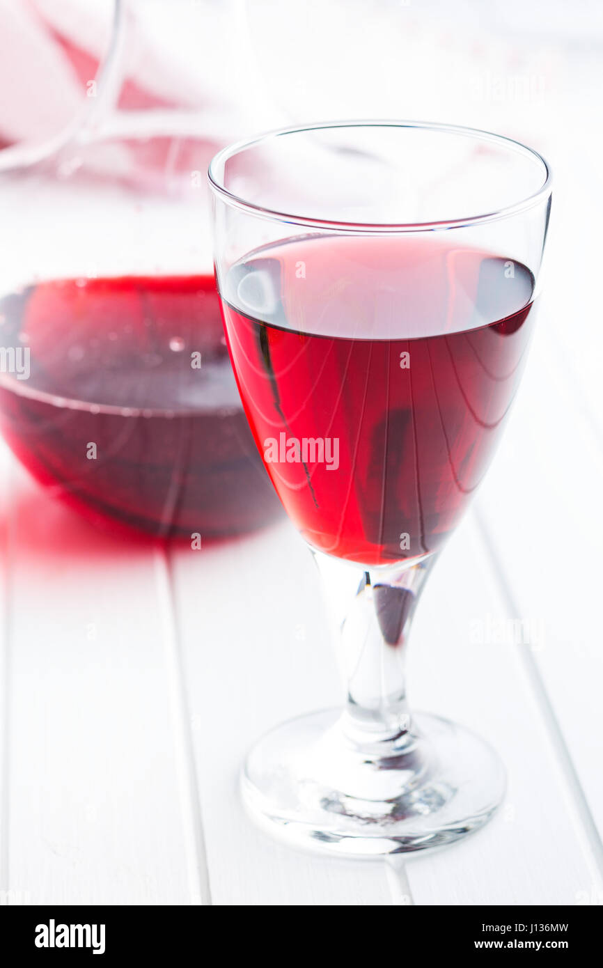 Glas Rotwein auf weißen Tisch. Stockfoto
