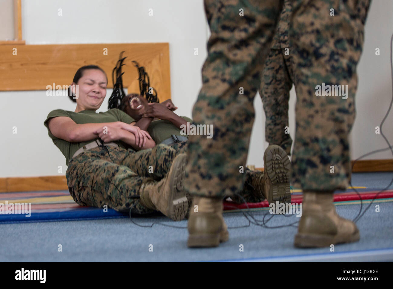 US-Marines mit Hauptsitz und Support Battalion (H & S BN), Marinekorps Installationen Pacific (MCIPAC) spannt sich während einer X26 Blitzeinschlages Taser beim Sicherheit Augmentation Force (SAF) Training am Camp Kinser, Okinawa, Japan, 13. April 2017. Marines während H & S BN, MCIPAC, Freiwillige zu SAF zertifiziert, um der Provost Marshal Büro bei Bedarf zu unterstützen. (Foto: U.S. Marine Corps MCIPAC Bekämpfung der Kamera Lance Cpl. Christian J. Robertson) Stockfoto