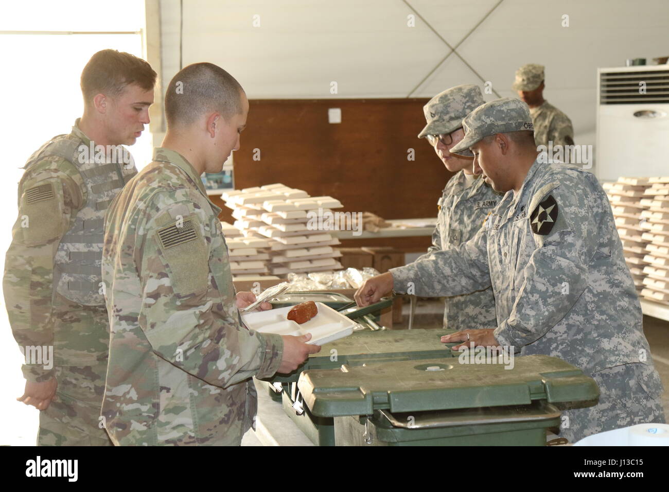 Zwei Soldaten des 571st nach vorne Unterstützungskompanie dienen eine warme Mahlzeit in der 19. Expedtionary Sustainment Command Dining Einrichtung im 1. Republik der Korea Marine Camp in Pohang, 14. April 2017. Stockfoto