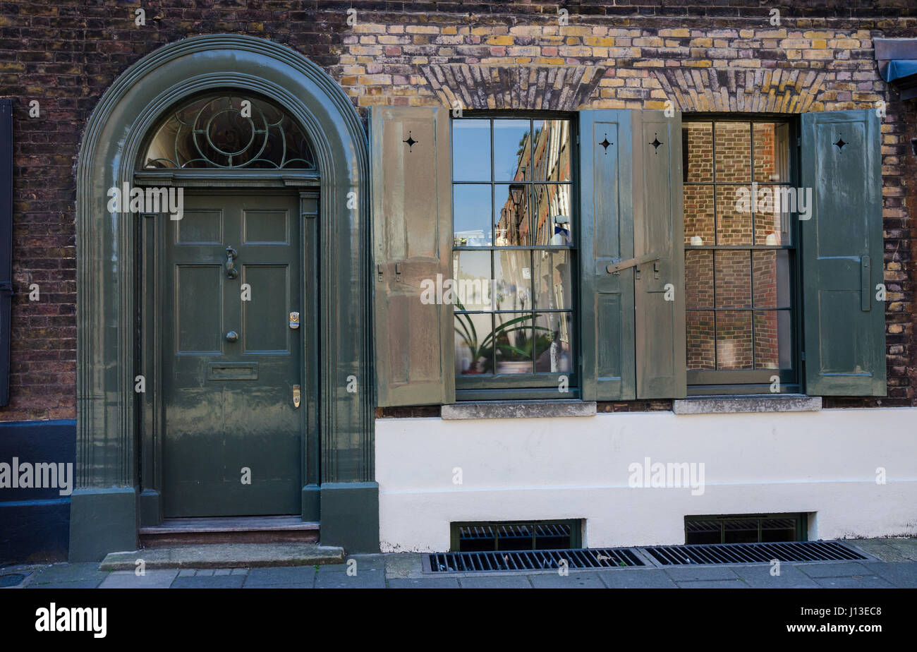 Die Front eines Hauses auf Princelet Street in East London mit einem reich verzierten Eingangstür und Rollläden an den Fenstern. Stockfoto