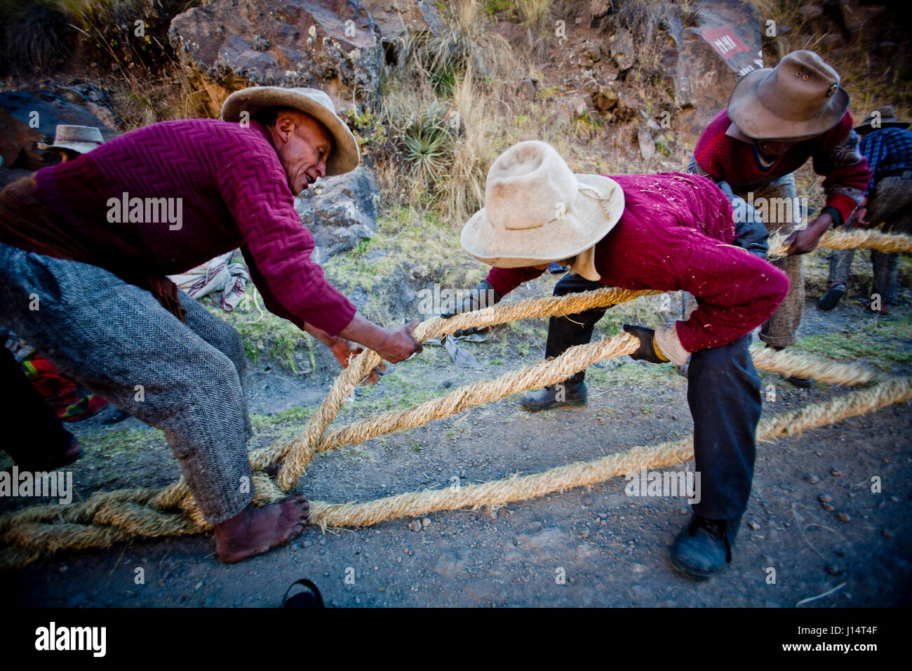 CUZCO, PERU: Einheimische Männer die kleineren Seile in größeren Seile Flechten. DABEI handlich-Handwerk auf einer neuen Ebene Bilder zeigen eine fünf Jahrhunderte alten Tradition wo Menschen vor Ort die ultimative handgefertigte 100-Fuß-langen Seilbrücke bauen. Tausend Dorfbewohner kommen zusammen in eine drei-Tage-Leistung in Abbau der alten Queswachaca-Brücke und Herstellung einer neuen, mit einer großen Feier am vierten Tag.  Diese Brücke ist die einzige Brücke dieser Art aus der Inka-Tradition bewahrt. Arbeiten bis zu zwölf Stunden pro Tag, Bilder zeigen die Bauabschnitten machen die kleineren Seile und dann Flechten sie in der Stockfoto