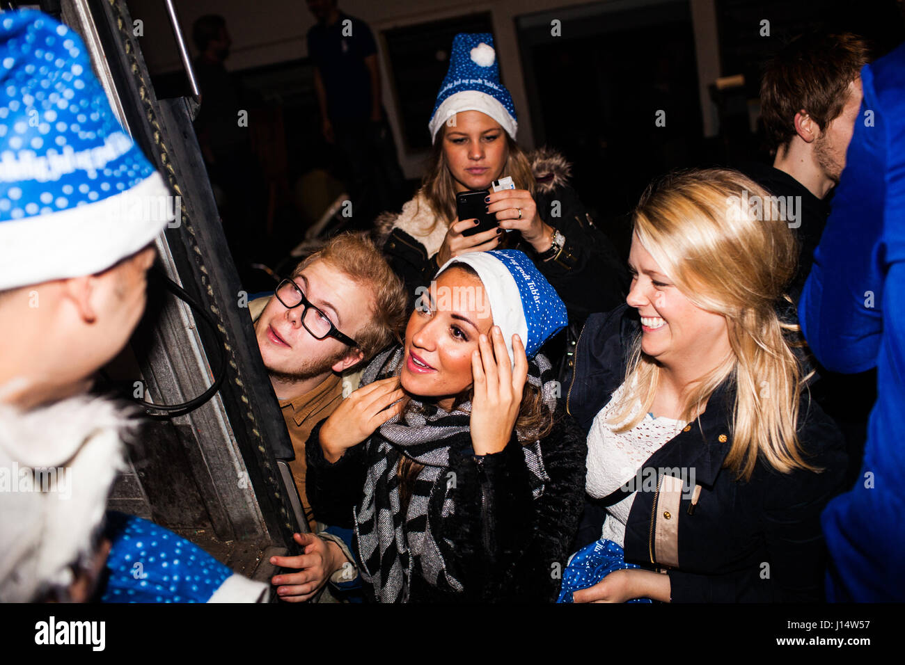 Nachtschwärmer sind aufgereiht draußen Bars und warten für einen LKW voller Weihnachten Elfen und Kobolde, die Freibier auf die Weihnachten Brauen wieder geben Stockfoto