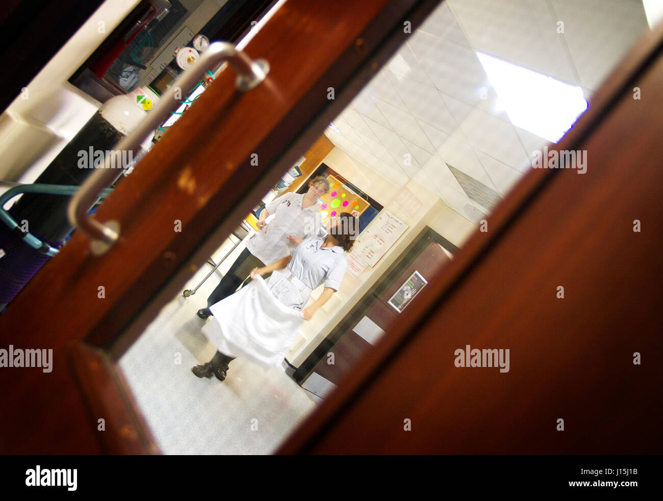 NHS medizinische UK Krankenhaus Blick durch Fenster durch Gemeinde-Empfang mit dem medizinischen Personal, die im Hintergrund laufen Stockfoto