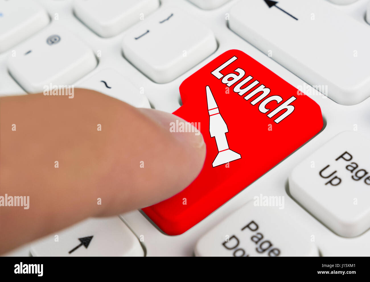 Finger eine Raketen-Start-Taste auf einer Computertastatur drücken. Stockfoto