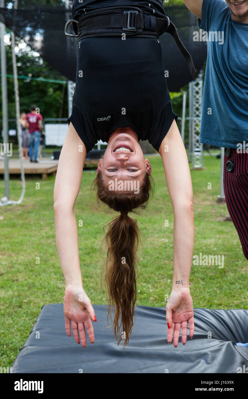 Isabella Mackie lernen, wie man von den Beinen, mit Hilfe der Lehrer Shane Gilman hängen. Die fliegenden Trapez Schule befindet sich im Regents Park ein Stockfoto