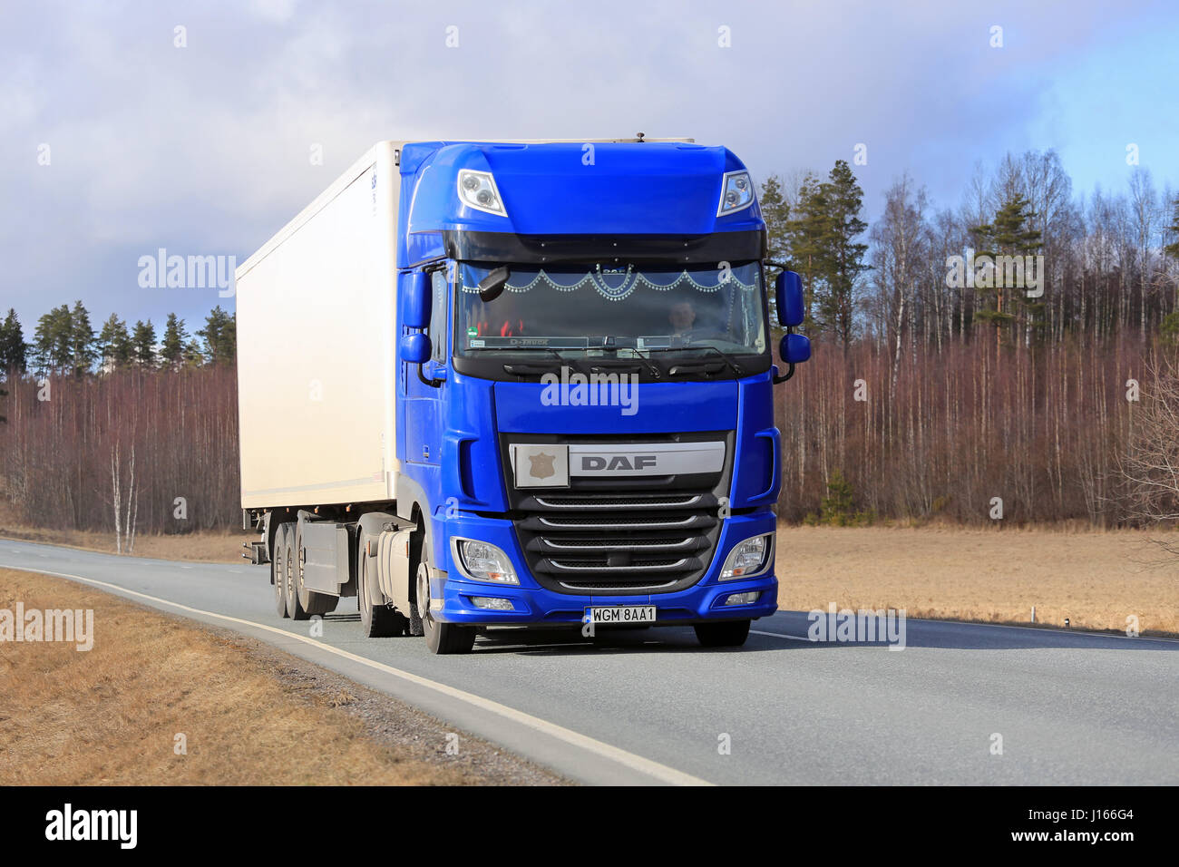 SALO, Finnland - 1. April 2016: Neues, blaues DAF XF Sattelschlepper bewegt sich auf ländlichen Autobahn im Süden von Finnland im Frühjahr. Stockfoto