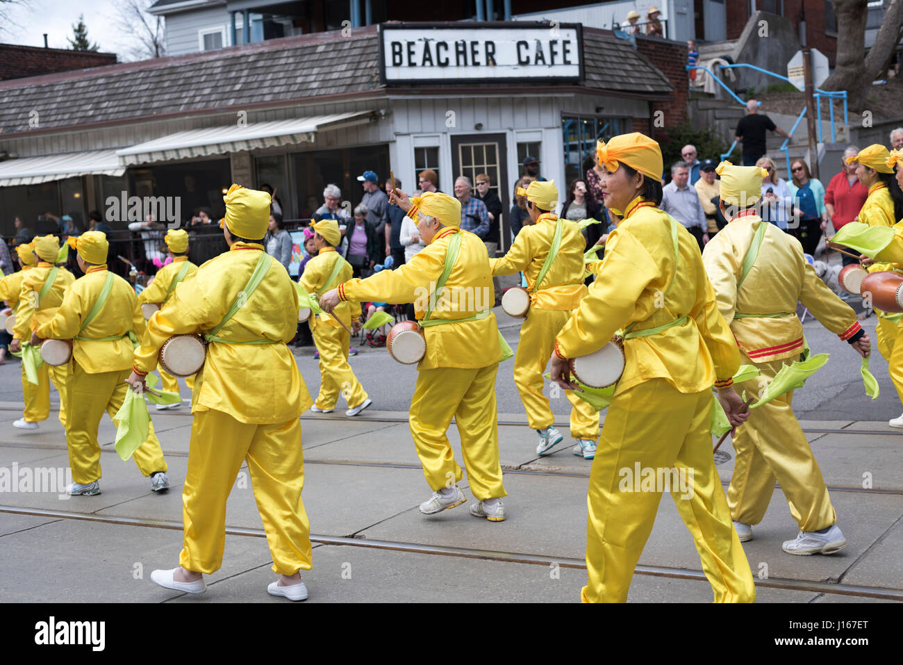 Falun Dafa marschierende Gruppe gekleidet in traditionellen chinesischen Kostümen spielen Taille Trommel während der Strände Easter Parade 2017 auf Queen Street East Toronto. Stockfoto