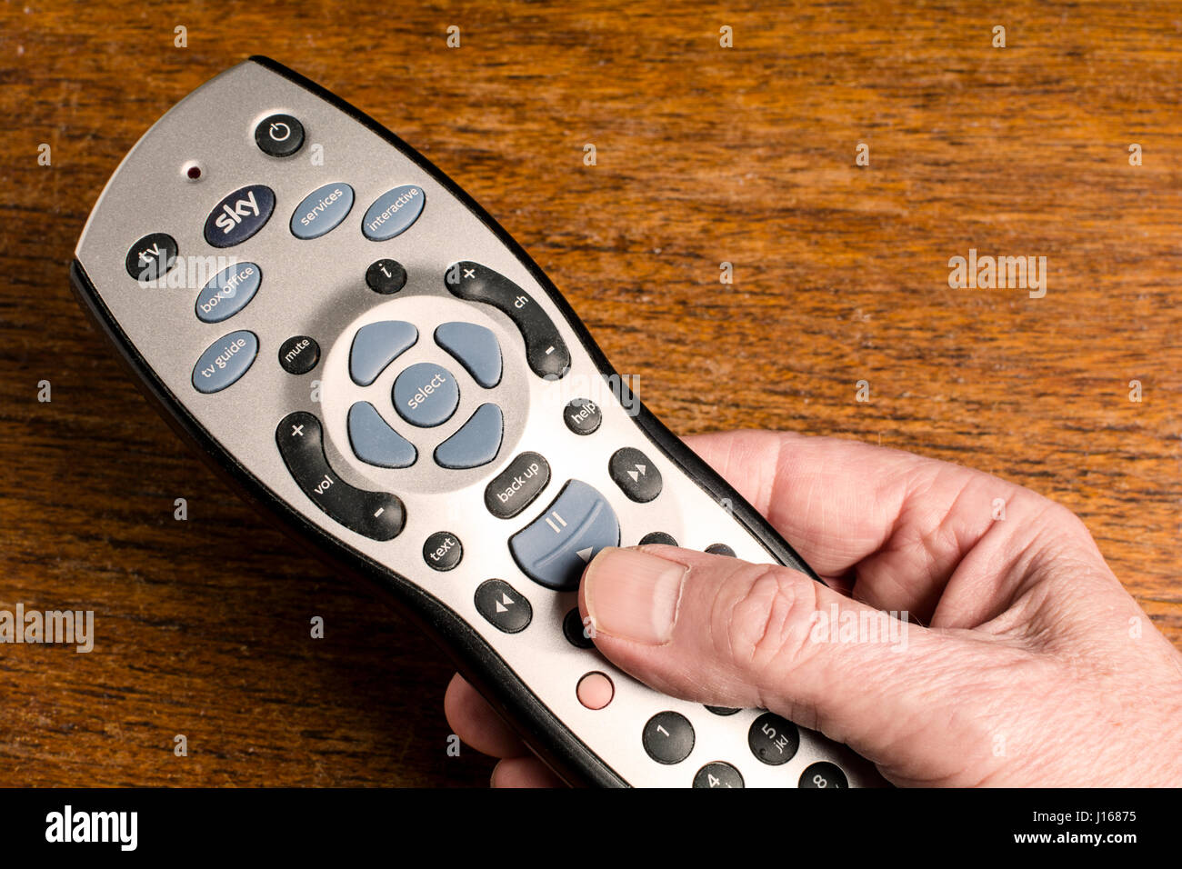 A mans Hand hält eine Sky + HD Fernbedienung Stockfoto