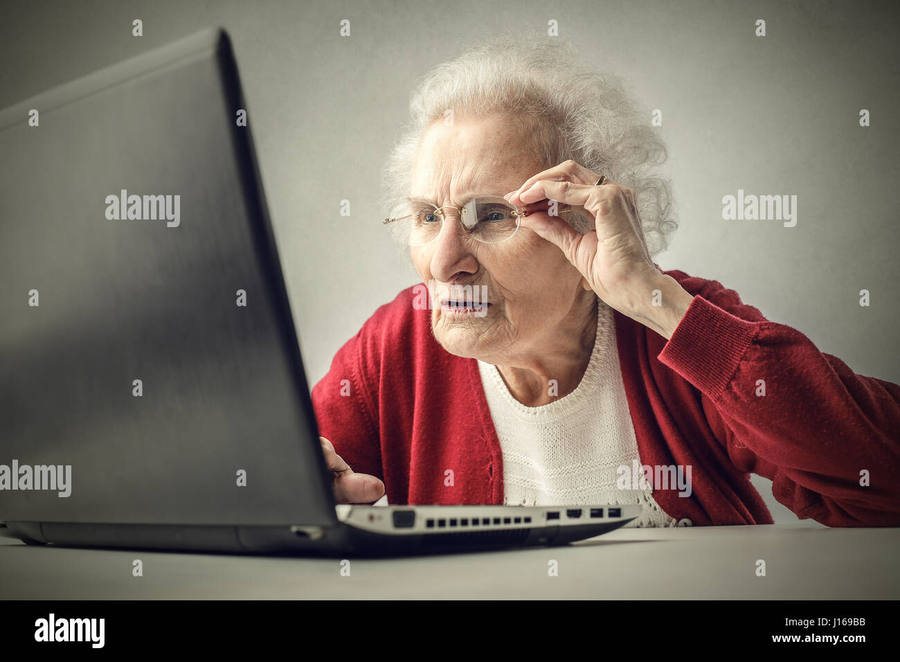 Alte Dame Blick auf laptop Stockfoto