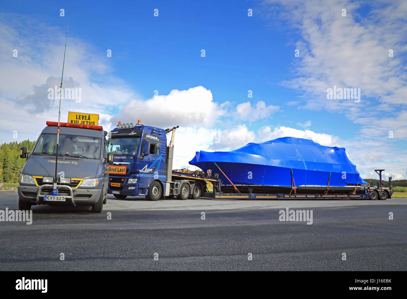 FORSSA, Finnland - 19. September 2015: Pilot Auto und außergewöhnliche Belastung sind zu einem Truck Stop verlassen. Ein Begleitfahrzeug mit Höhe Mess Pol ist Stockfoto