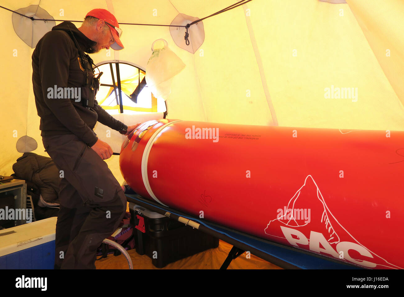 Ein Berg-Ranger und Sanitäter pumpt Luft in eine tragbare Höhe Kammer In Medical Camp auf Denali Stockfoto