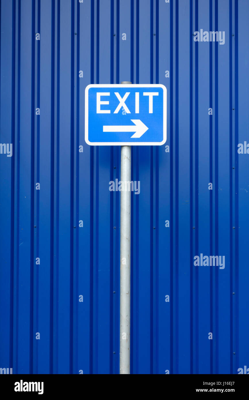 Eine blaue 'Exit'-Schild nach rechts zeigt, vor einem blauen Hintergrund. Konzeptionelle Bild von Hardliner Tory Politik in Bezug auf Europa und die EU Stockfoto